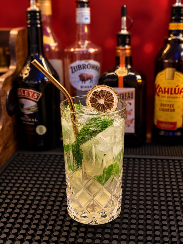 Cocktail avec feuilles de menthe, citron et glaçons au comptoir du Phoenix Bar