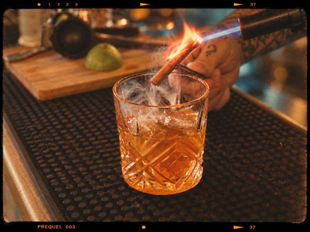 Préparation de l’Old Fashioned Jamaïcan avec une fumée de cannelle au Phoenix Bar